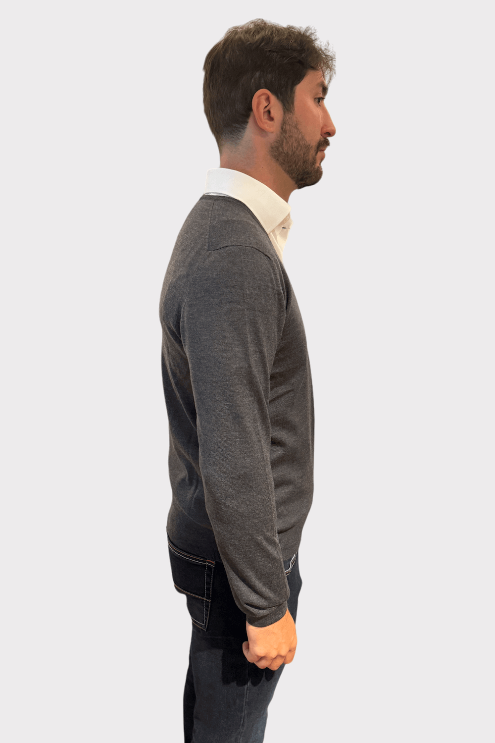Pull en laine col en V gris porté par un homme avec chemise blanche, parfait pour un look élégant.