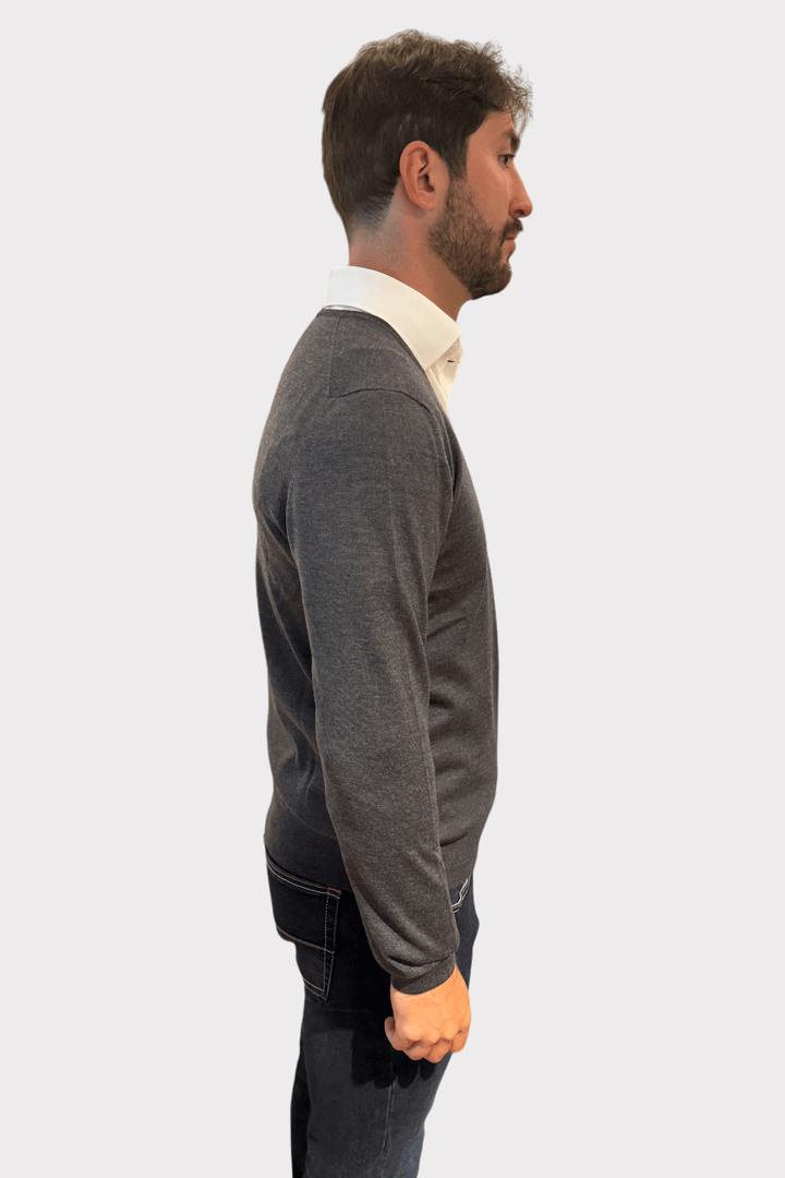 Pull en laine col en V gris porté par un homme avec chemise blanche, parfait pour un look élégant.
