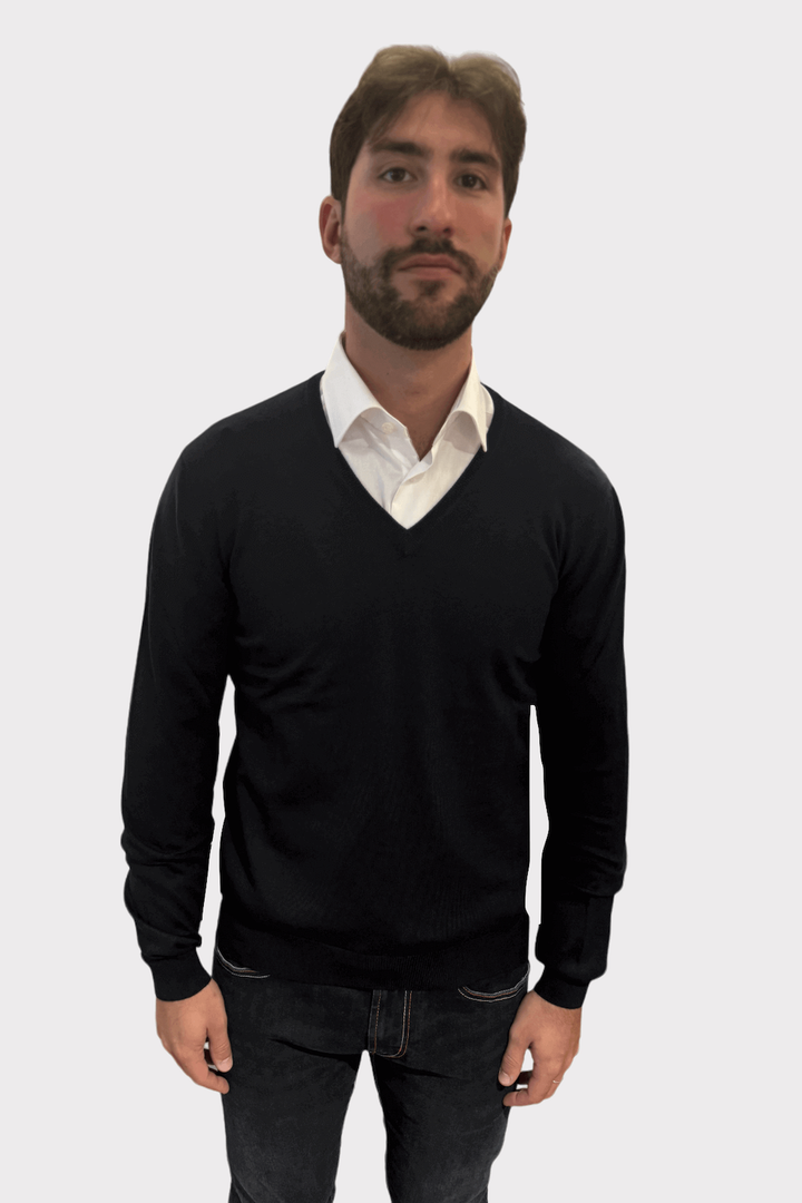 Homme portant un chandail col en V de laine, chic et confortable, sur une chemise blanche.