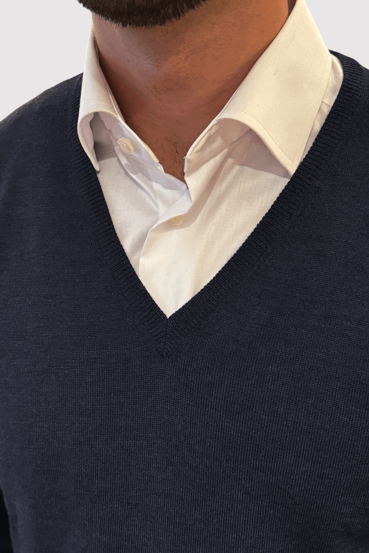 Pull col en V en laine, élégant et confortable, porté sur une chemise blanche, ajustement parfait.