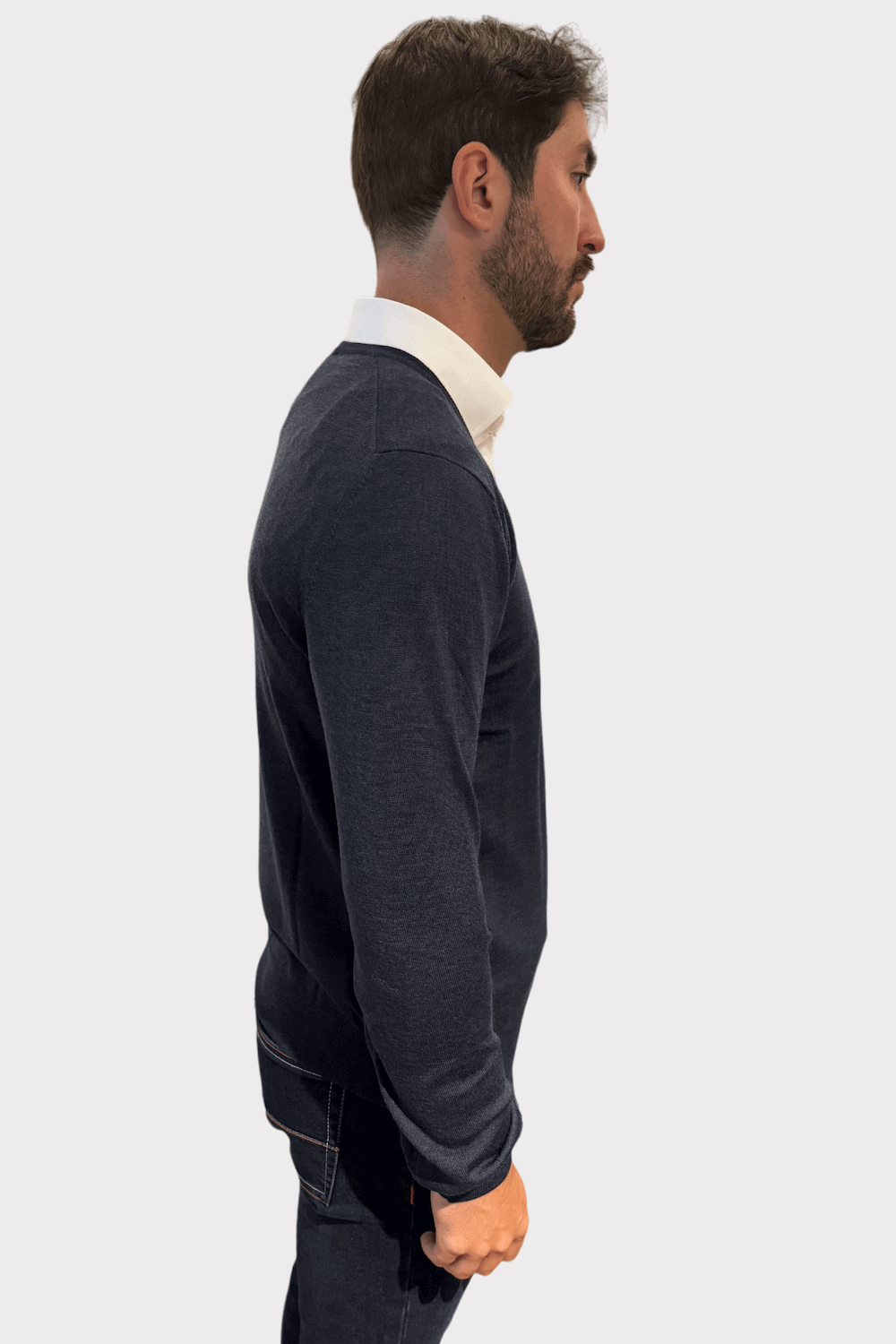 Chandail col en V en laine pour homme, porté avec une chemise, offrant confort et style élégant.