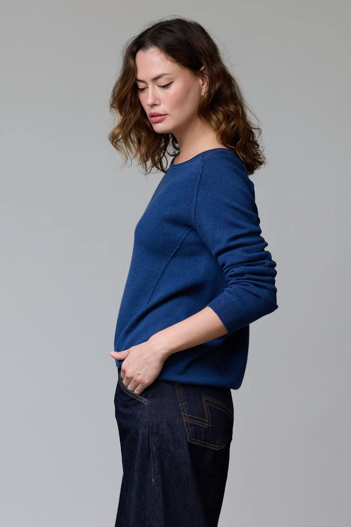 Chandail à col rond bleu, coupe classique et maille luxueuse, porté par une femme pour un style épuré ou habillé.