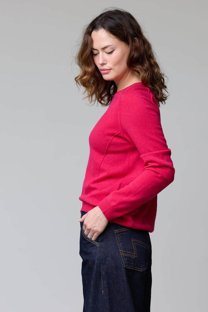 Femme portant un chandail à col rond rouge, coupe classique, avec des finitions côtelées, pour un look élégant et confortable.