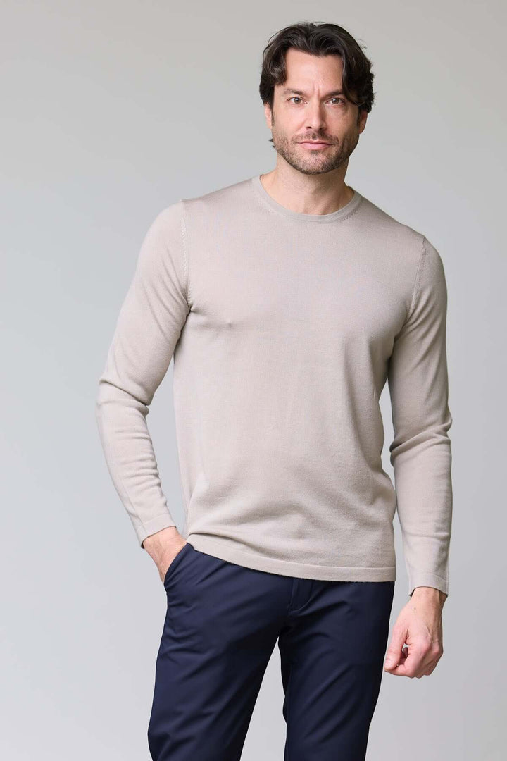 Homme portant un chandail col rond en tricot fin, couleur beige, élégant et confortable, idéal seul ou sous un veston.