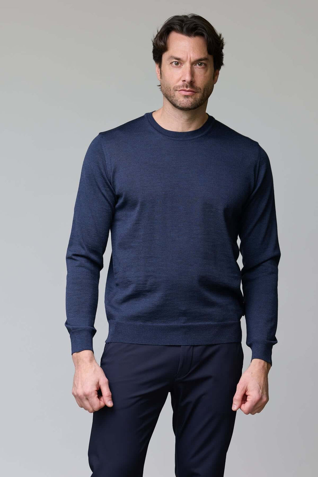 Homme portant un chandail col roulé en laine mérinos bleu, coupe moderne ajustée.