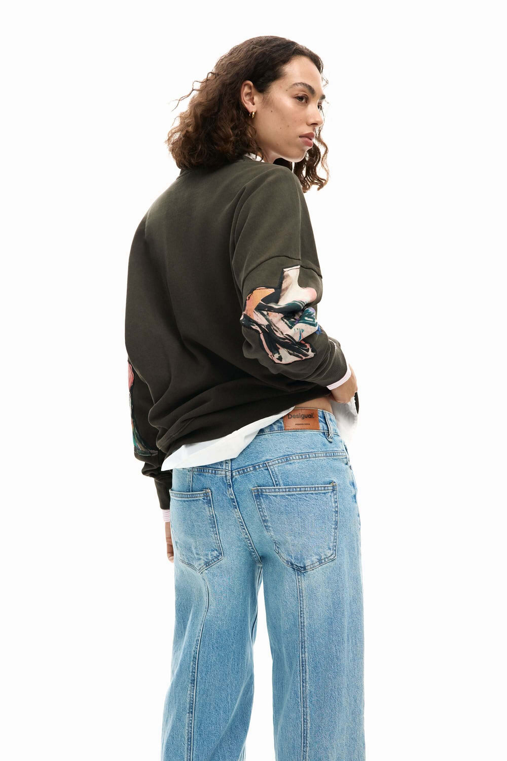 Femme portant un chandail collage dessin avec un motif artistique, coupe droite et des manches longues, idéal pour une tenue casual.