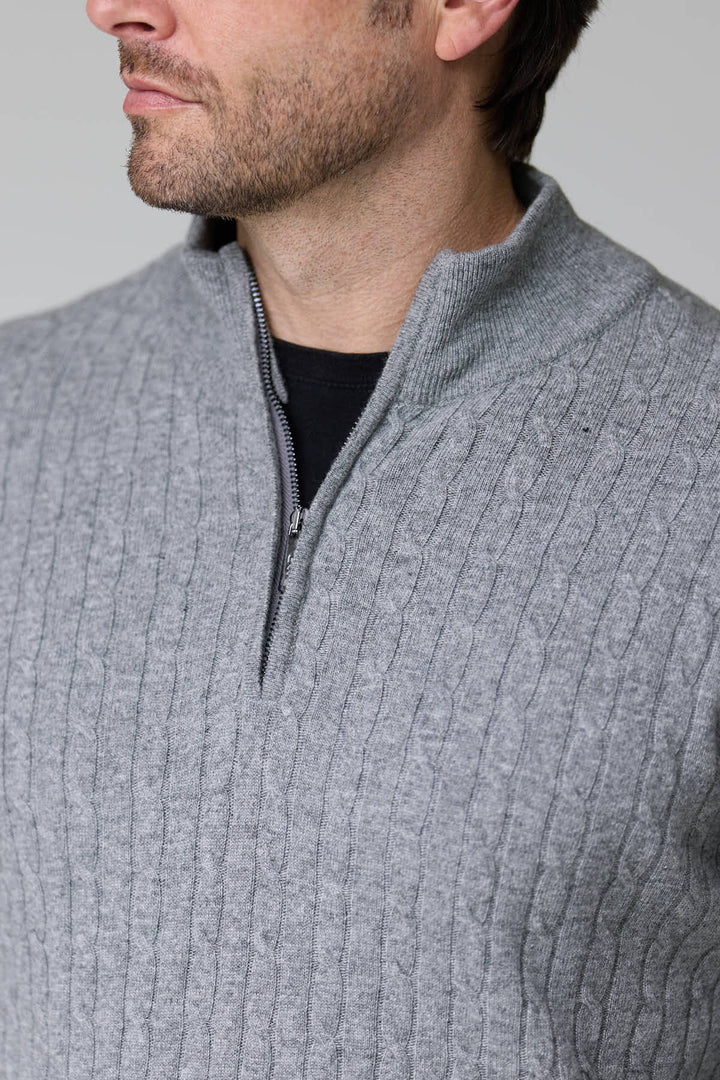 Homme portant un chandail à demi-glissière torsadé en laine, couleur gris, avec motif torsadé classique et col montant.
