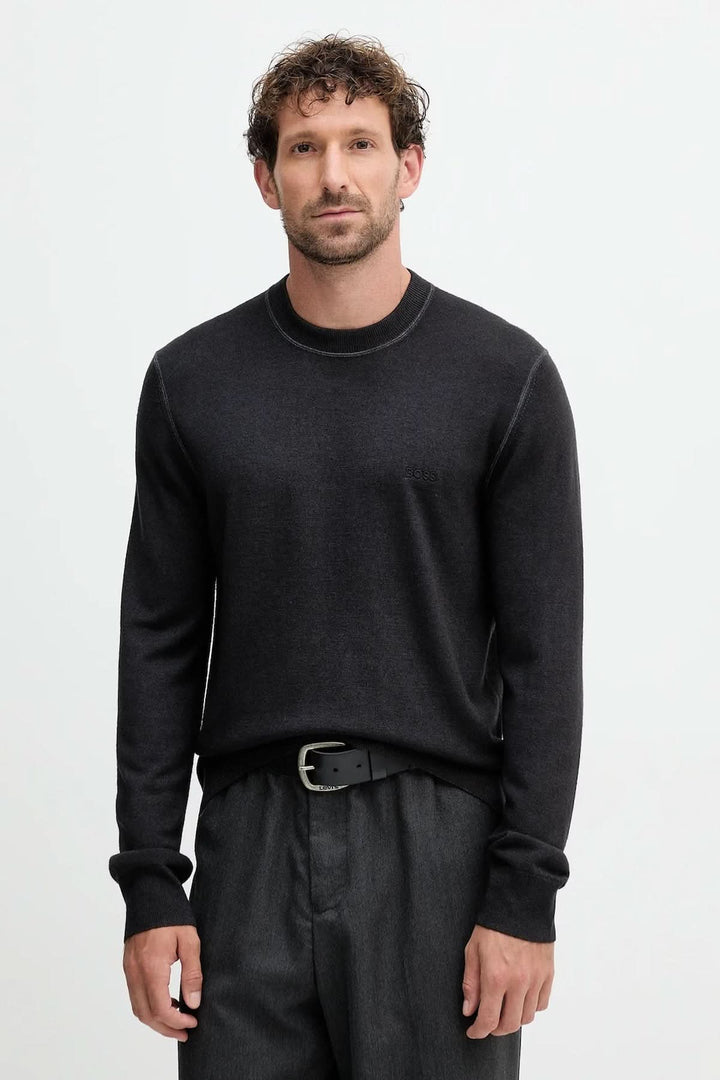 Homme portant un Chandail en laine vierge à col rond noir de la collection BOSS Orange avec manches longues et finitions côtelées.