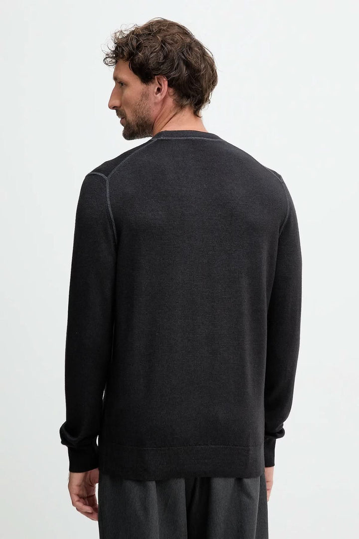 Homme portant un chandail en laine vierge à col rond, vu de dos, couleur noire, de la collection BOSS Orange.
