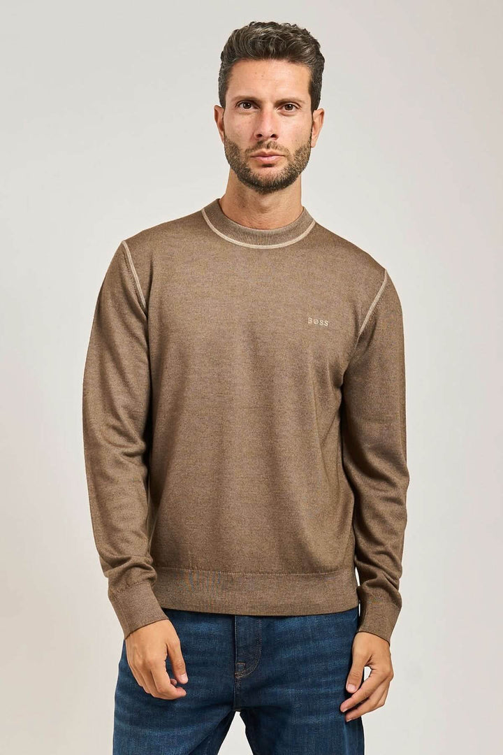 Homme portant un chandail en laine vierge à col rond BOSS Orange, couleur marron, manches longues, logo brodé visible.