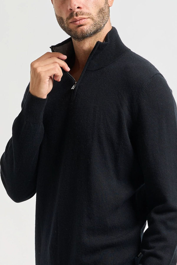 Homme portant un chandail en laine vierge à col rond coupe ajustée noir, manche retroussée, style élégant et confortable pour l&