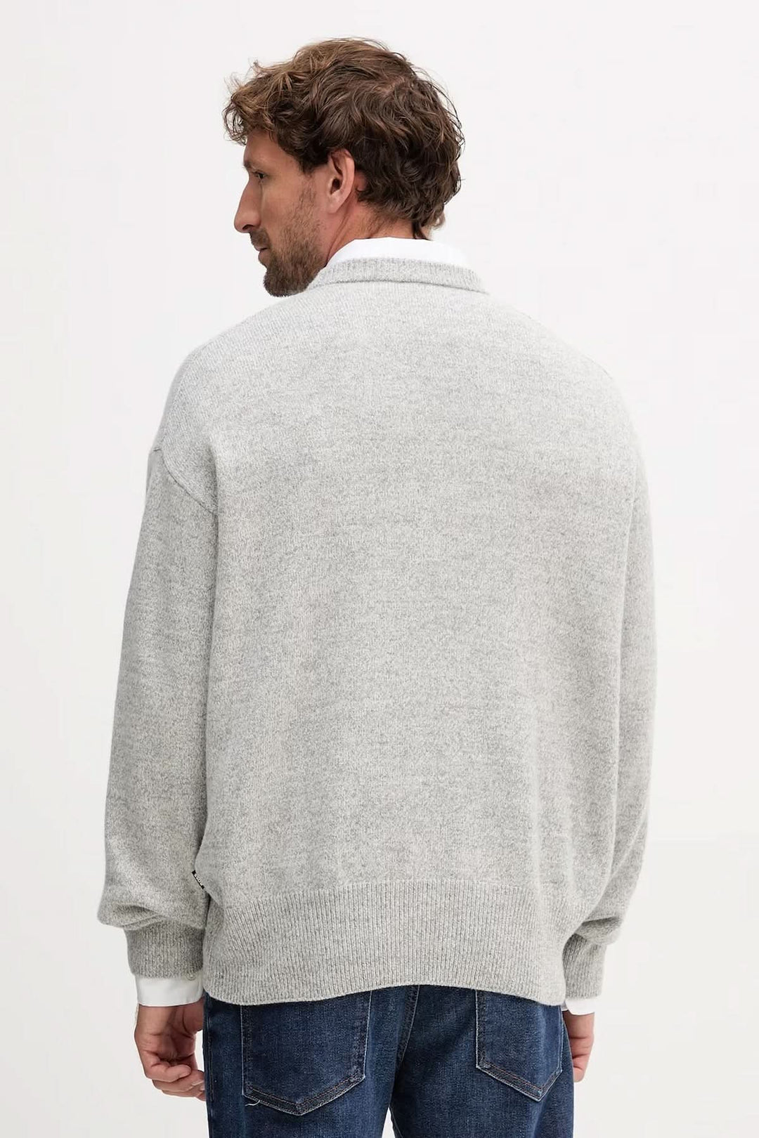 Homme portant un chandail en laine vierge coupe "oversize" BOSS gris avec finitions côtelées, vue arrière.