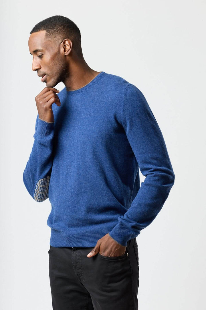 Homme portant un chandail en laine vierge et cachemire Gran Sasso bleu avec coudières pied-de-poule, chic et confortable.