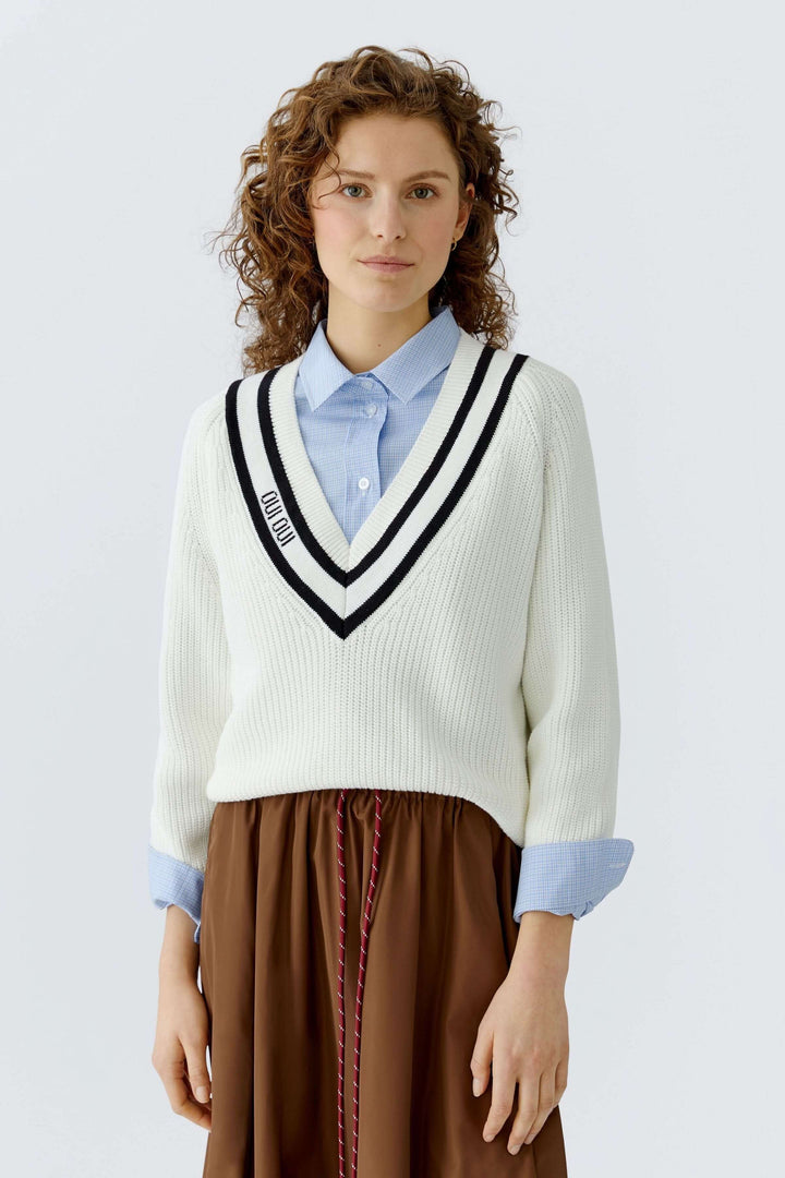 Femme portant un chandail en maille encolure en V, idéal pour un look élégant et confortable.
