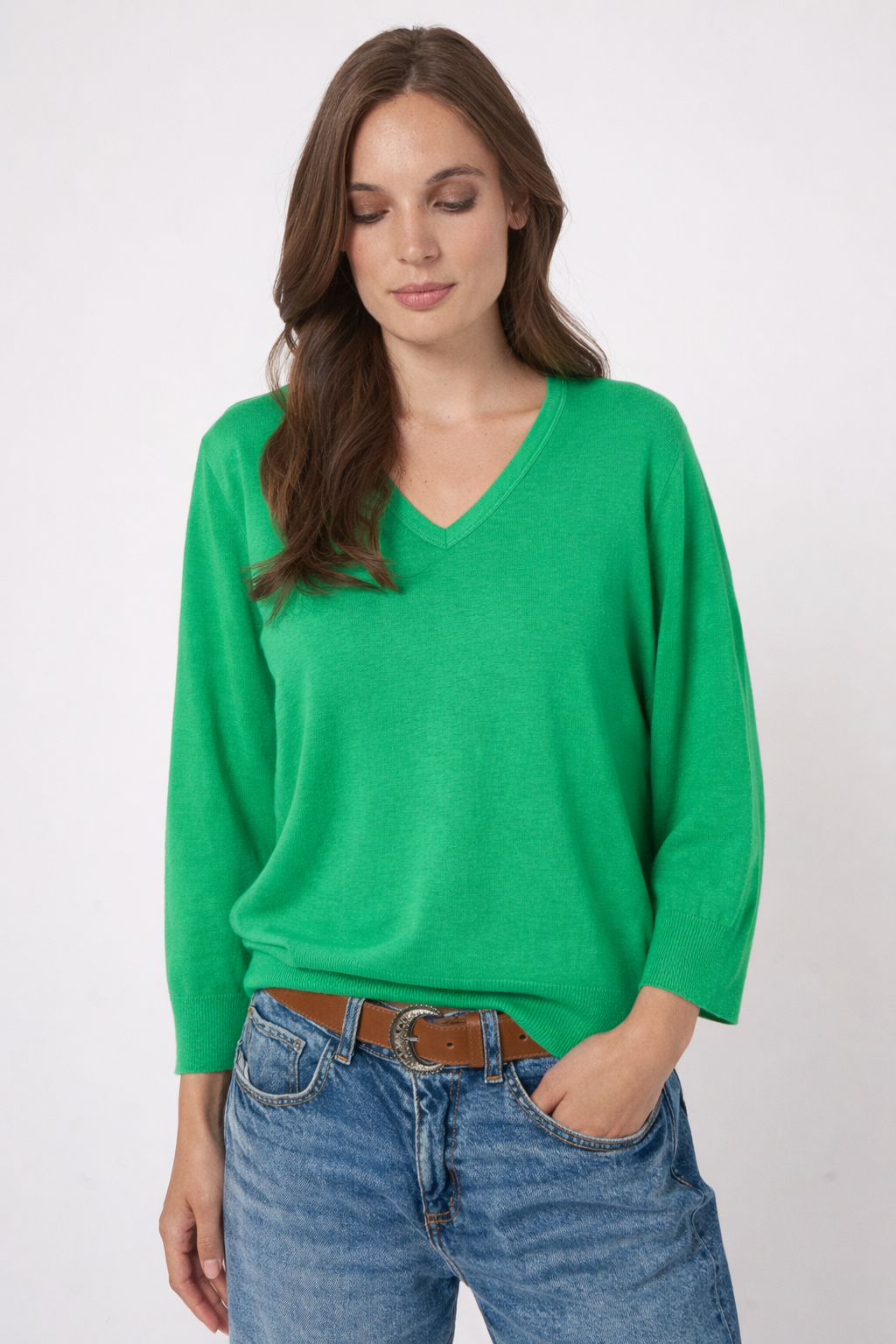 Chandail en tricot à col en V vert porté par un modèle, coupe droite et manches longues, look décontracté.
