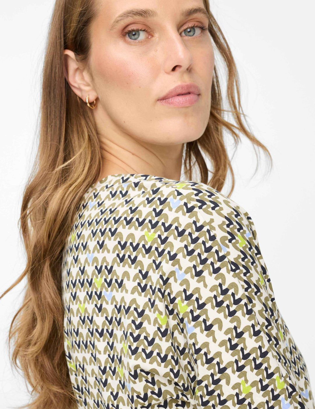 Chandail imprimé graphique CHARLENE avec imprimé dynamique et moderne, manches trois-quarts et encolure ronde pour un look élégant.