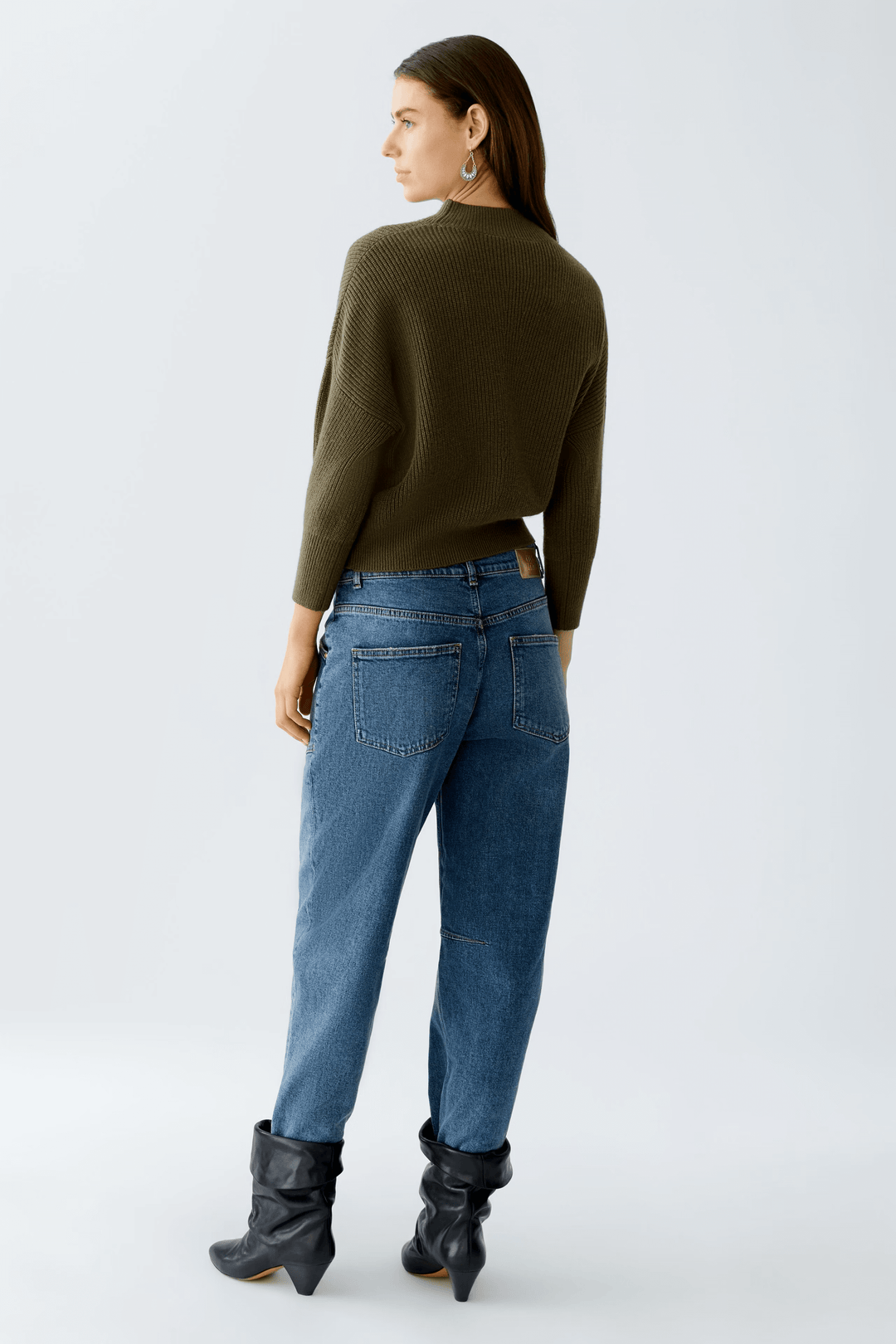 Femme portant un chandail maille fine et un jean, vue arrière.