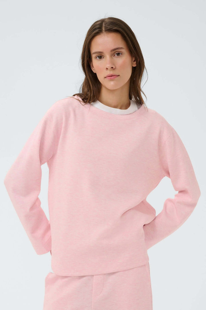 Chandail molletonné Gincent rose porté par une femme, coupe droite et confortable, idéal pour un style moderne et décontracté.