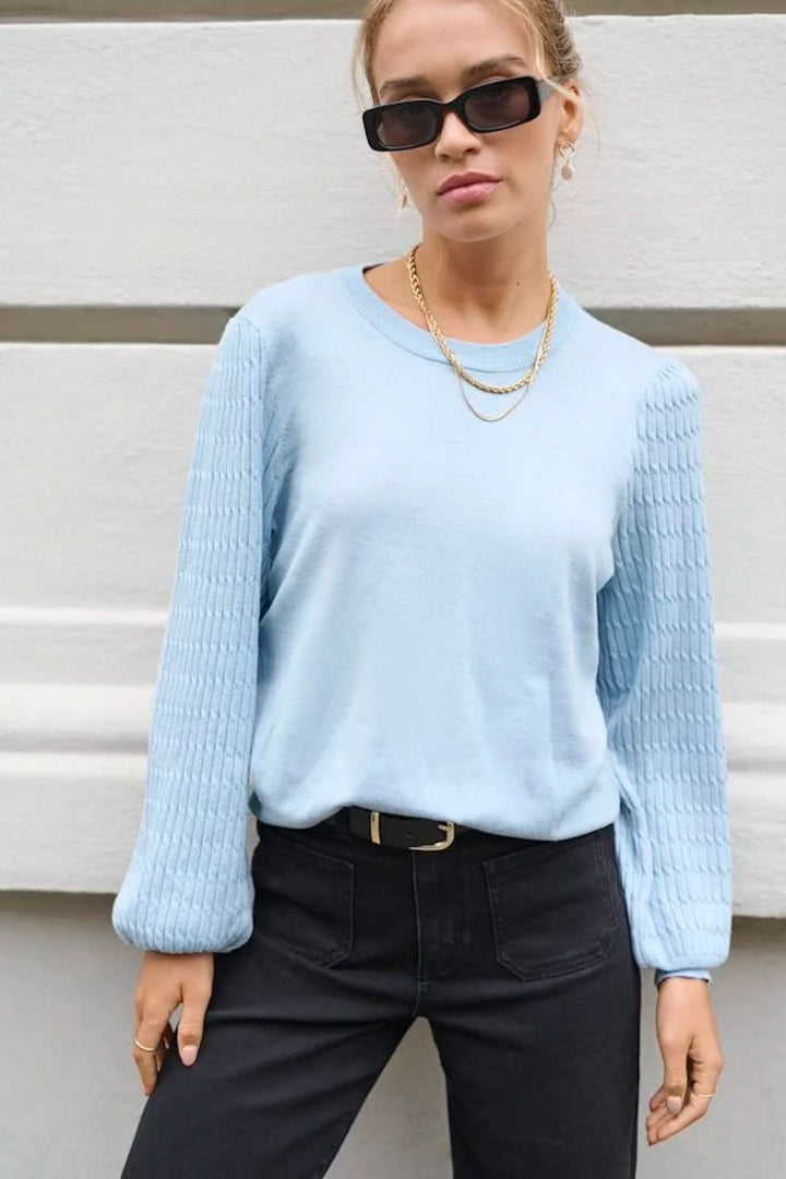 Chandail en tricot bleu clair avec manches texturées, idéal pour un look décontracté et confortable.