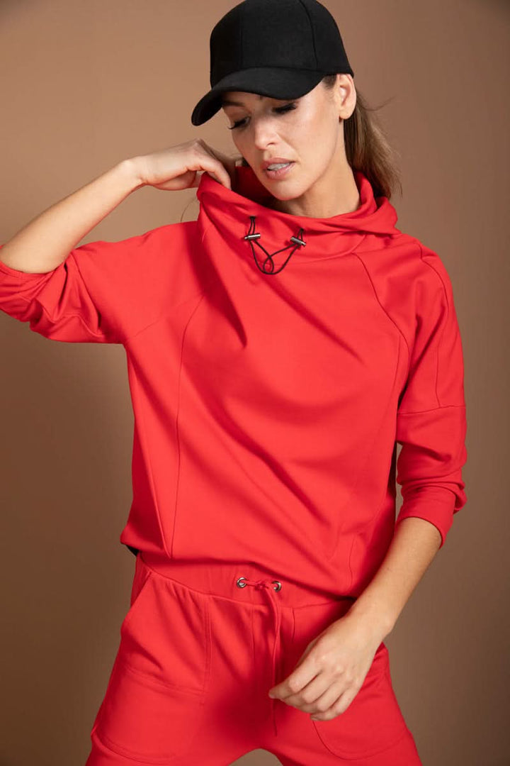 Chandail structuré rouge athleisure avec col montant à cordon, pour un look moderne et dynamique. Parfait en ensemble ou seul.