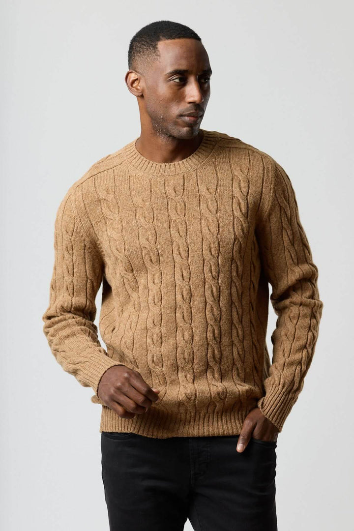 Homme portant un chandail torsadé col rond beige pour un look décontracté et élégant.
