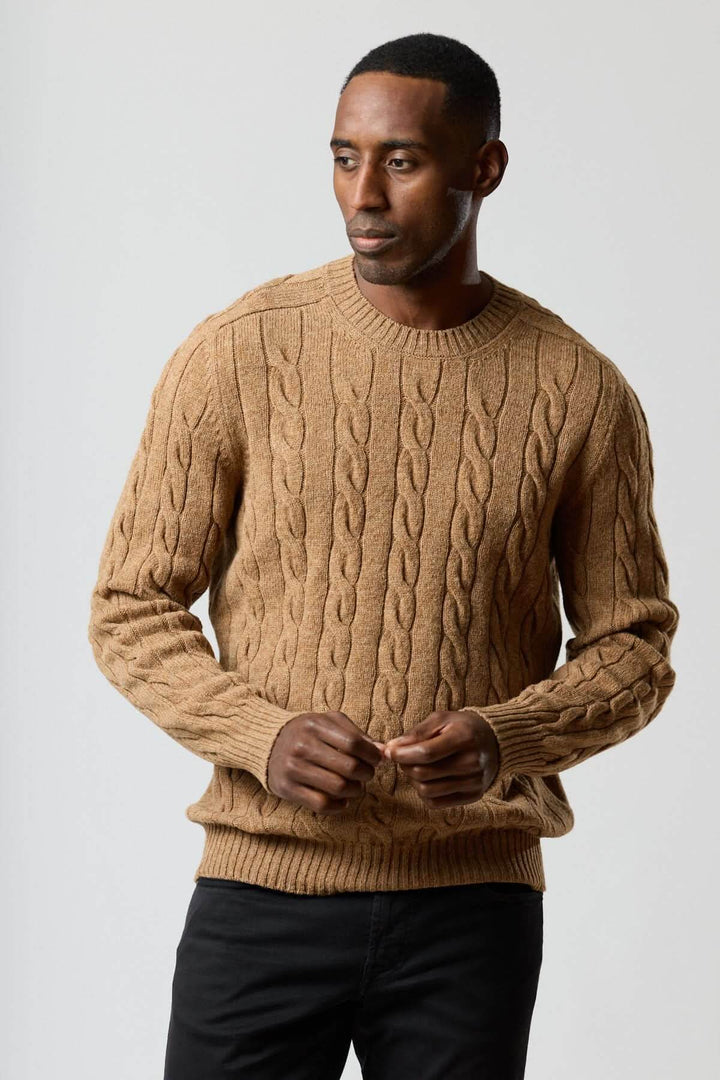 Homme portant un chandail torsadé col rond en maille câblée marron, idéal pour un look masculin et confortable au quotidien.