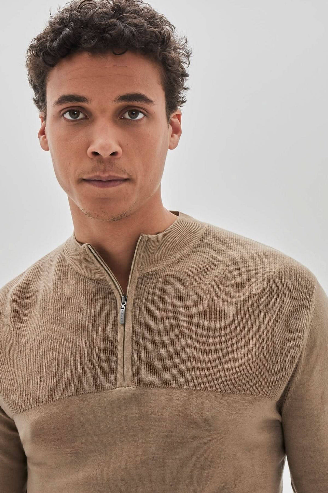 Homme portant un chandail zippé Newbury en laine mérinos extrafine, couleur beige, style moderne.