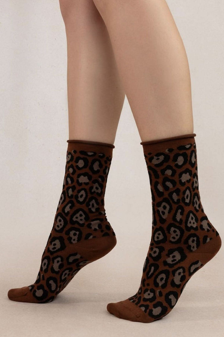 Chaussettes léopard confortables en laine et coton, avec un imprimé intégral tendance sur un fond marron.