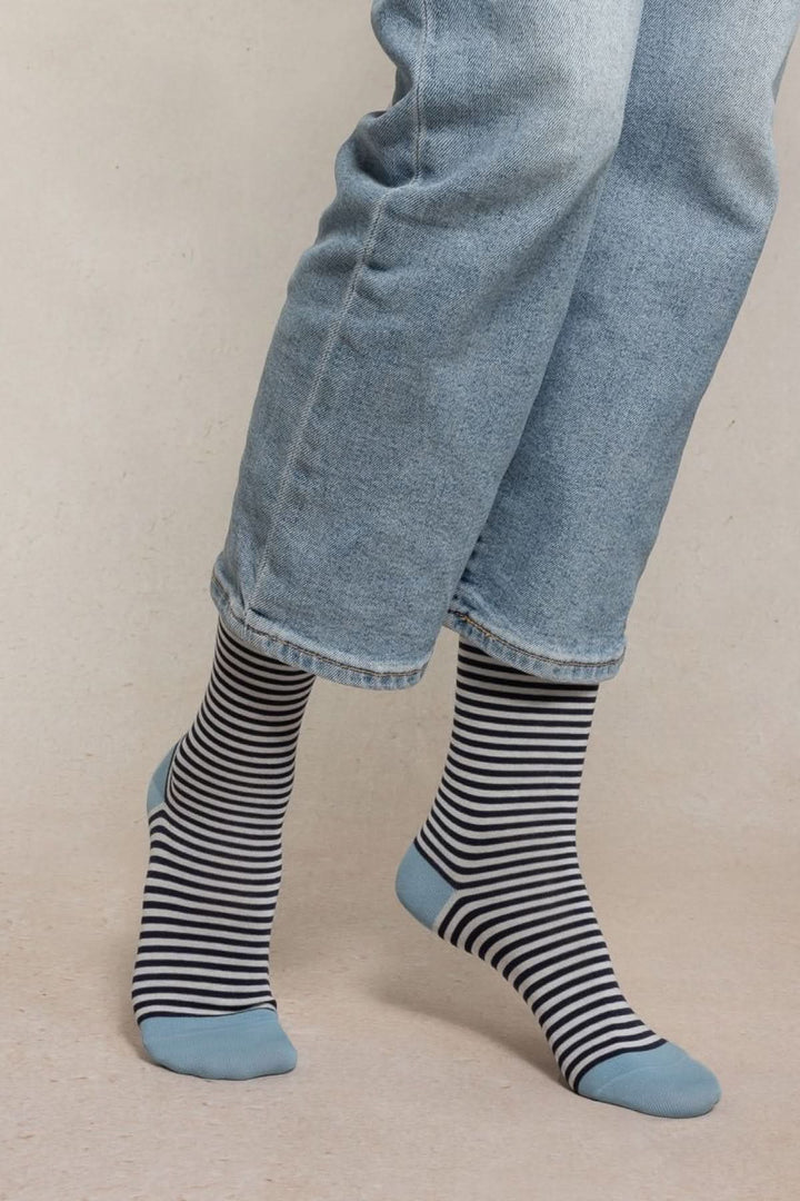 Chaussettes à rayures fines en maille douce et respirante, avec pointe et talon contrastés, portées avec un jean.