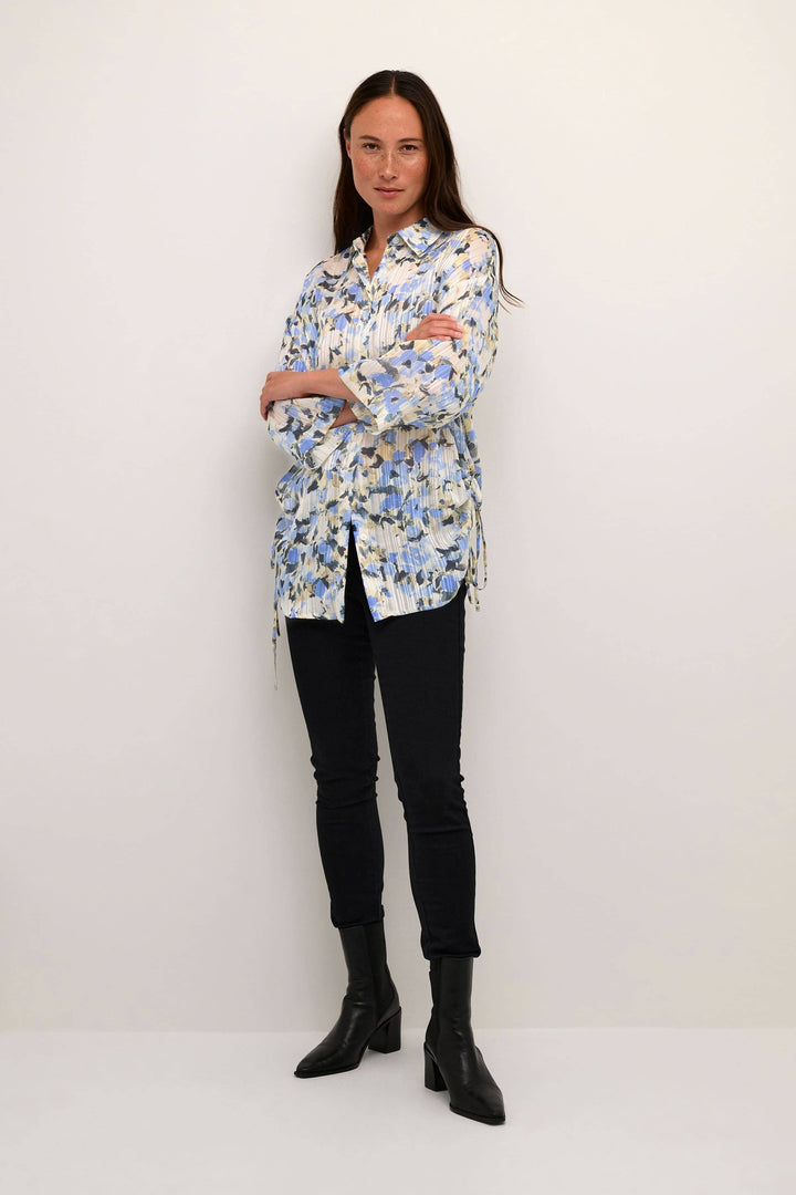 Chemise Eva à imprimé floral, manches 3/4, coupe régulière, portée avec un pantalon noir et des bottines.