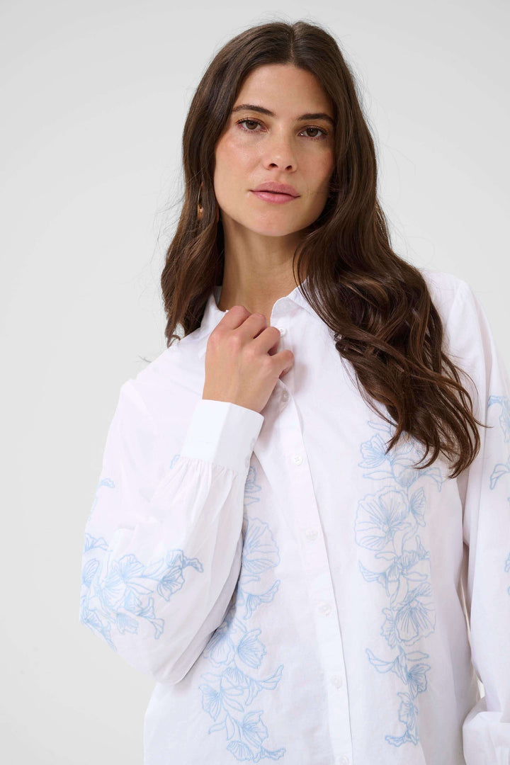 Chemise Jolene avec motif floral délicat et coupe fluide, idéale pour un style féminin raffiné et confortable.