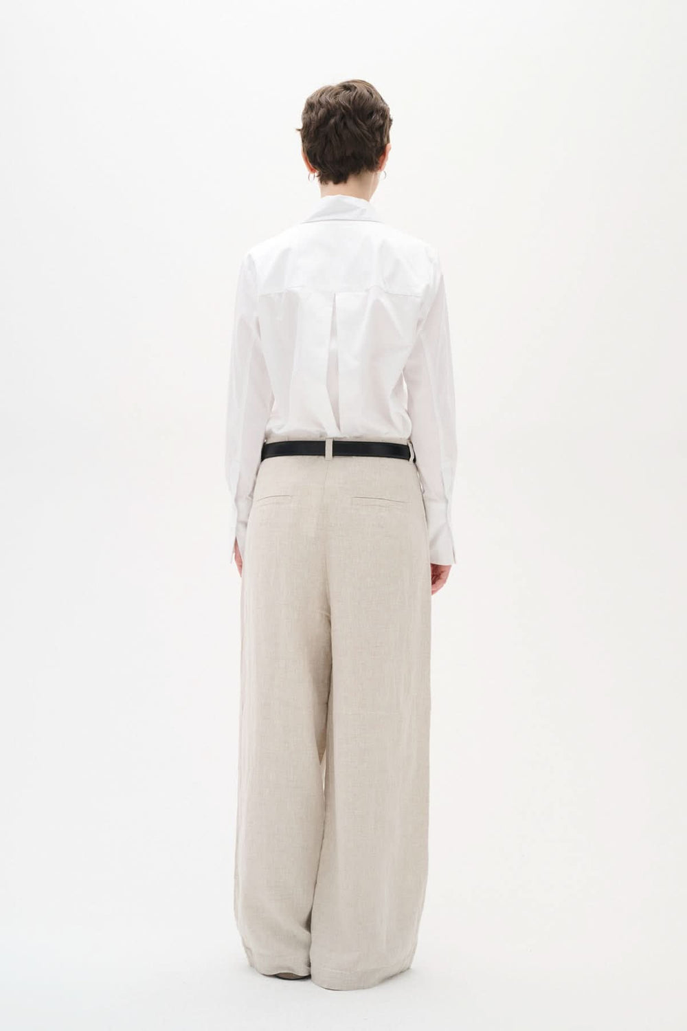 Chemise Vex blanche à manches longues vue de dos, portée avec un pantalon large beige.