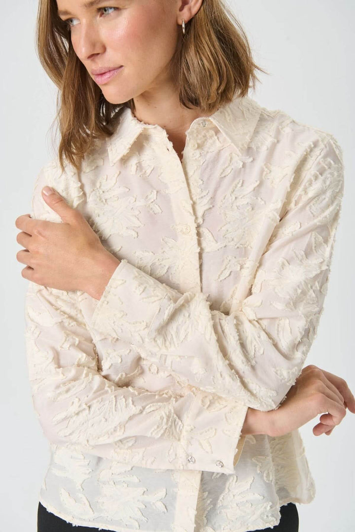 Chemise Vilya à relief floral ton sur ton en viscose semi-transparente, manches longues, col classique, élégante et confortable.