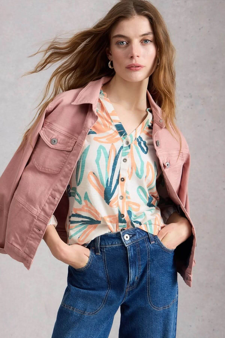 Femme portant une chemise boutonnée col en V manches trois-quarts Annie avec veste rose et jean.