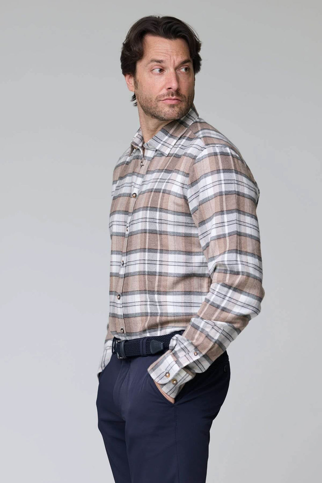 Homme portant une chemise à carreaux chevrons beige et gris en flanelle douce, style décontracté et élégant, coupe ajustée.