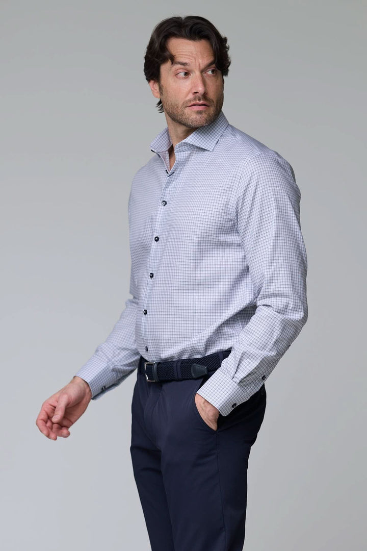 Homme portant une chemise à carreaux fins, manches longues, coupe ajustée, idéale pour un look professionnel et décontracté.