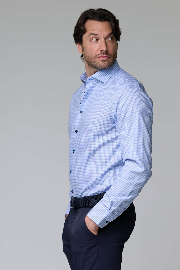 Homme portant une chemise à carreaux fins avec manches longues, coupe ajustée, tissu respirant, look professionnel et décontracté.