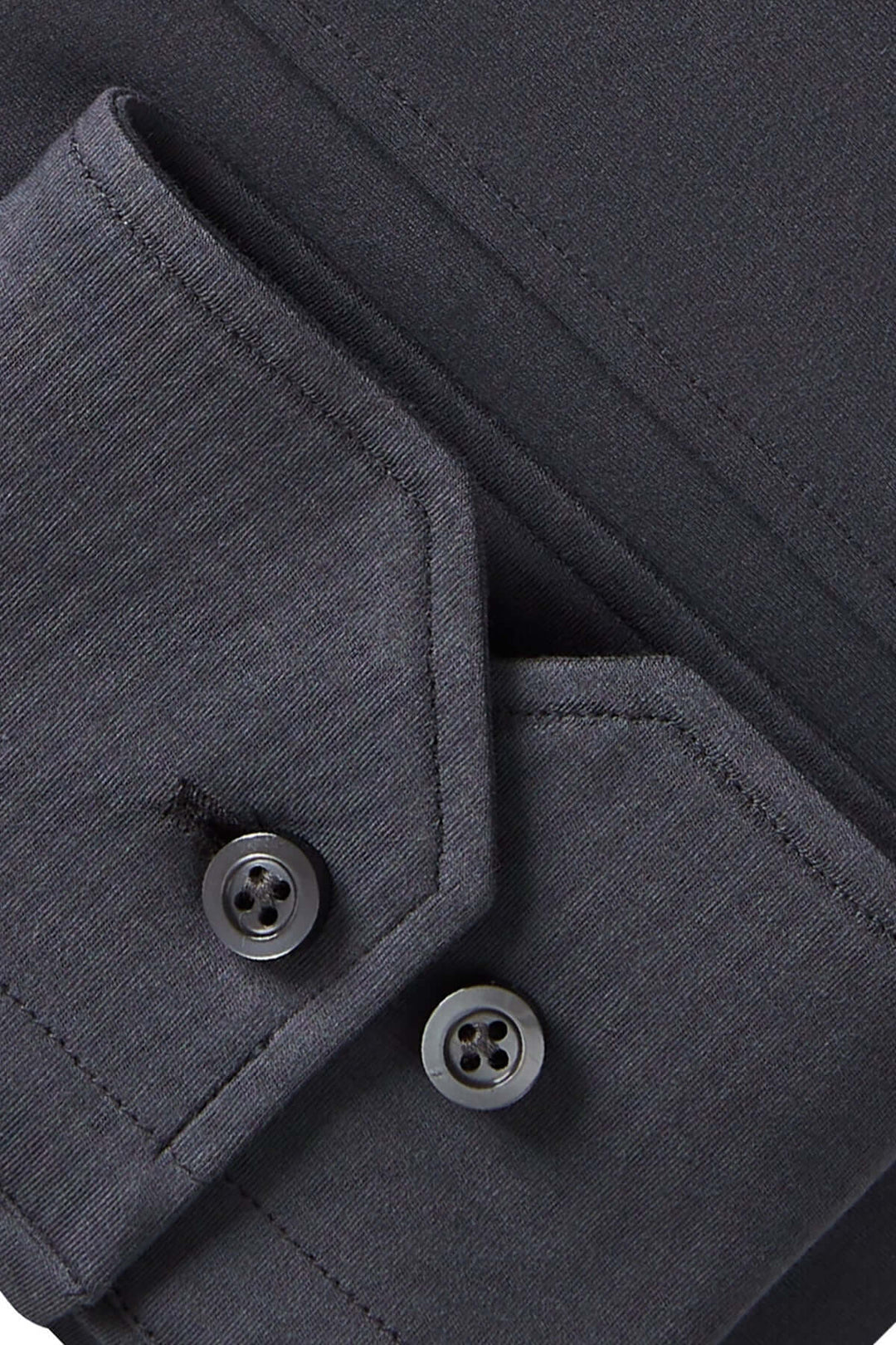 Détail d'une chemise élégante avec poignets ajustables et boutons ton sur ton sur un fond sombre.