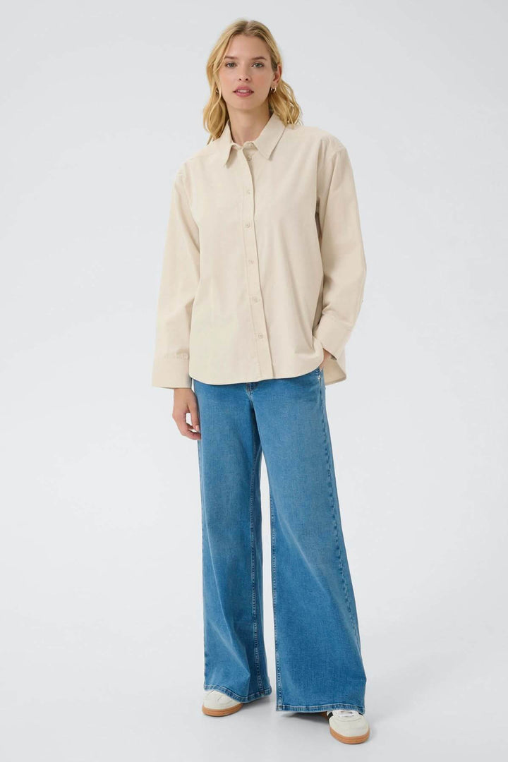 Femme portant une chemise en corduroy fin Savannas avec un jeans, style décontracté et élégant.