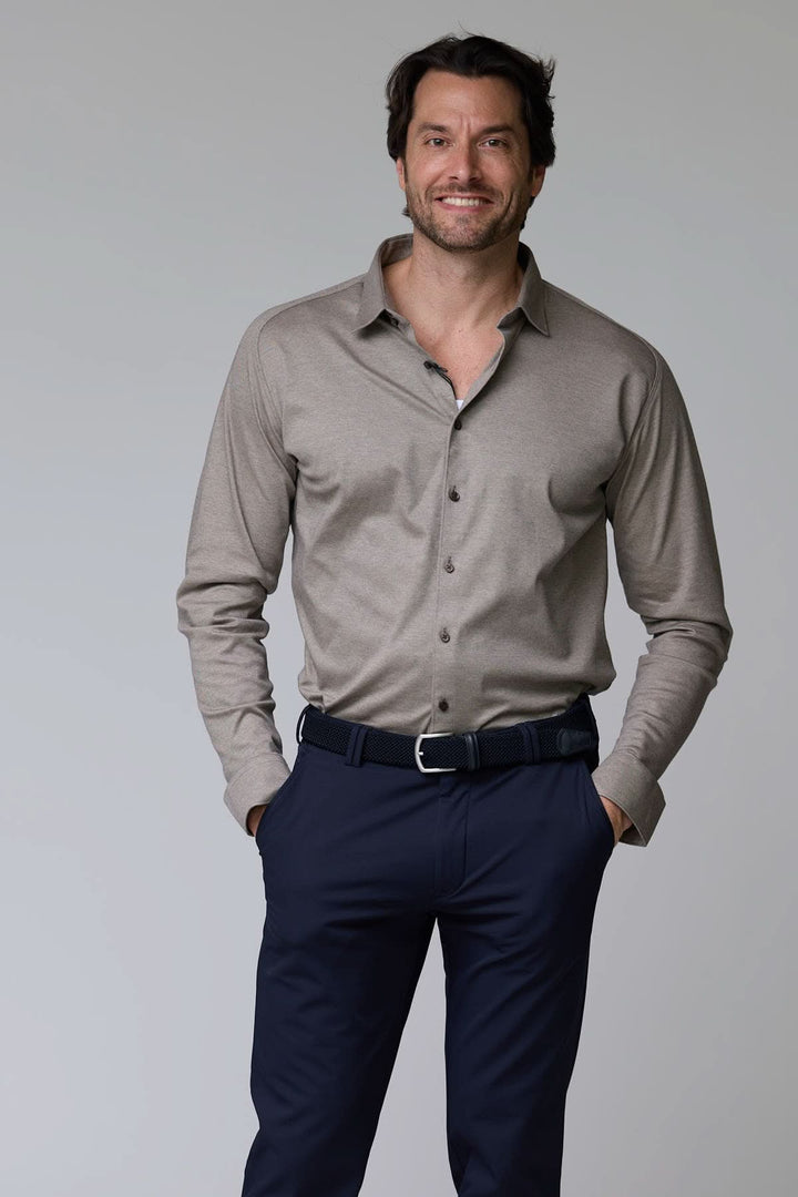 Homme portant une chemise en jersey extensible beige avec un col rigide, combinant style classique et confort moderne.