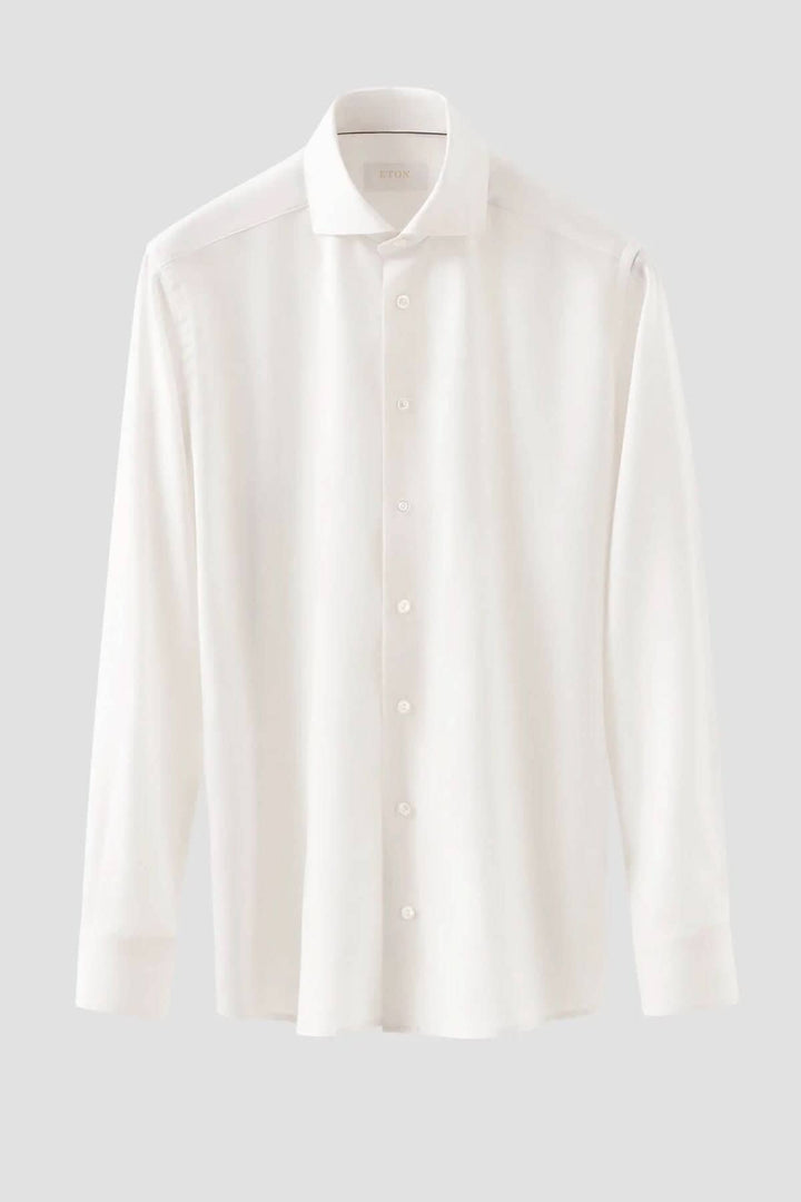 Chemise blanche en laine mérinos, élégante et confortable, parfaite pour un look soigné en été.