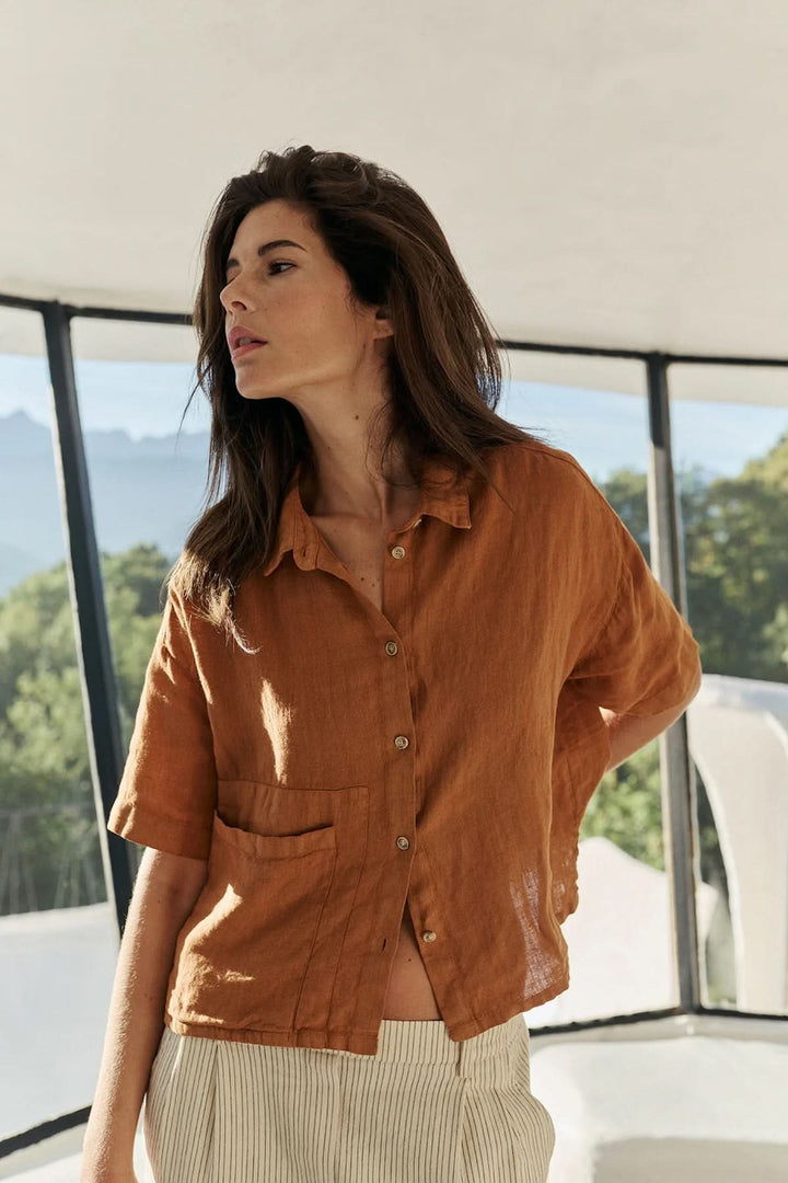 Femme portant une chemise en lin à coupe décontractée couleur marron, idéale pour un style estival et décontracté.