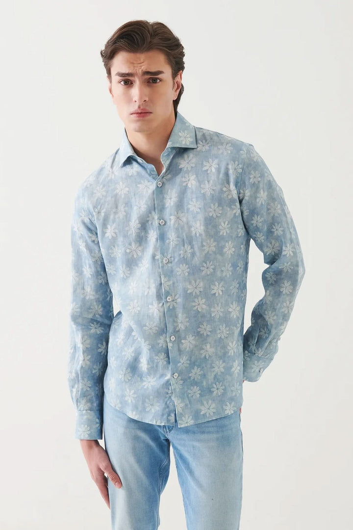 Chemise en lin à motif floral, légère et élégante, parfaite pour une tenue décontractée. Modèle en bleu avec fleurs.