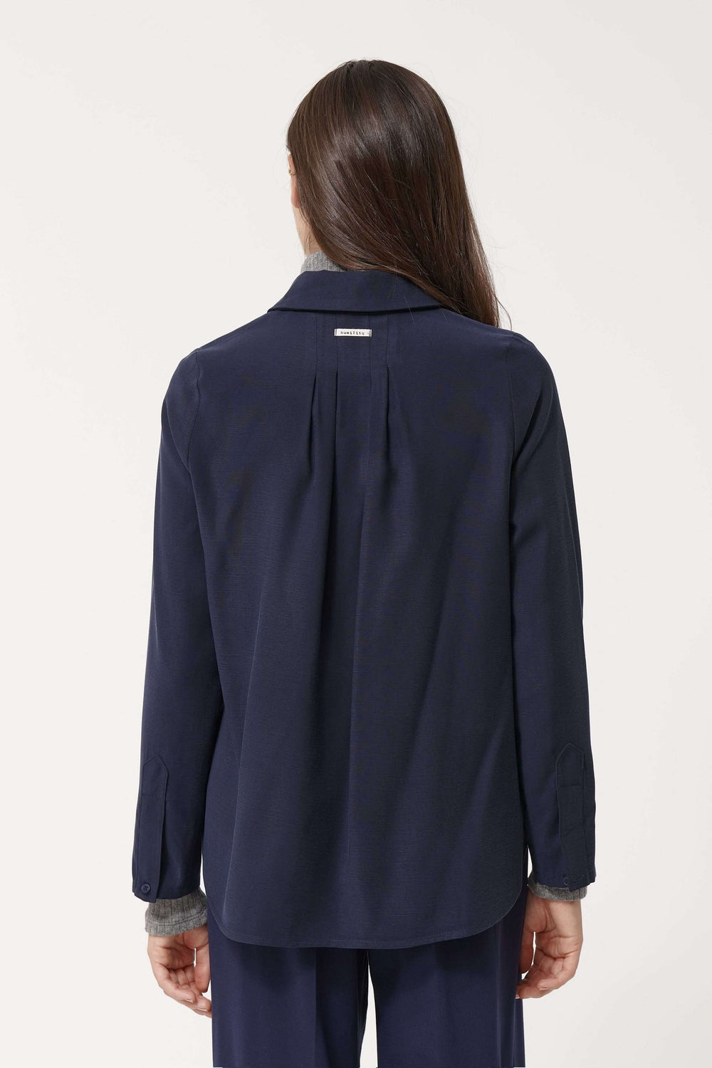 Vue arrière d'une chemise fluide élégante, coupe ample et col classique, idéale pour un style chic et minimaliste.