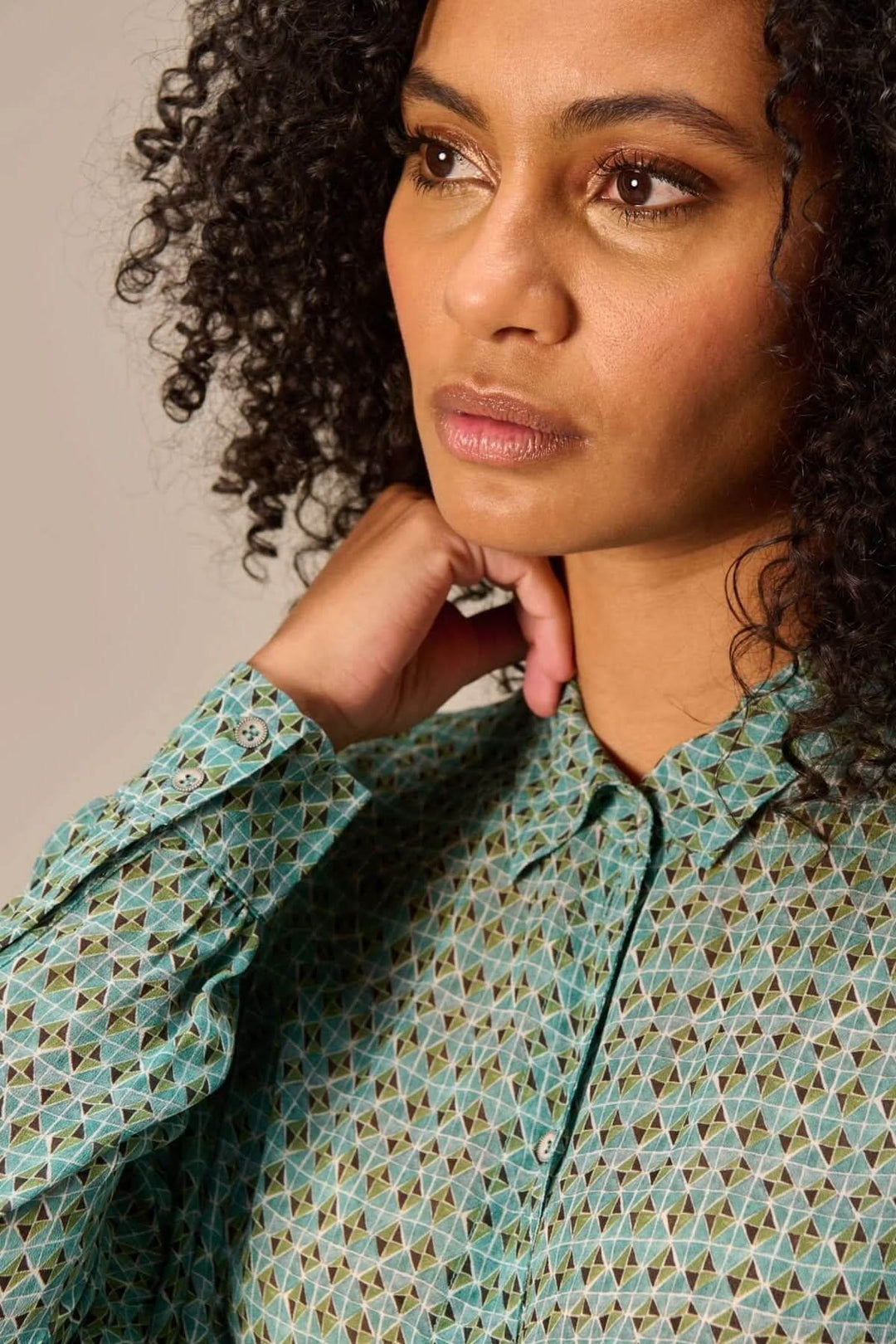 Chemise fluide imprimé à motifs géométriques portée par une femme, col classique, coupe décontractée, look moderne.