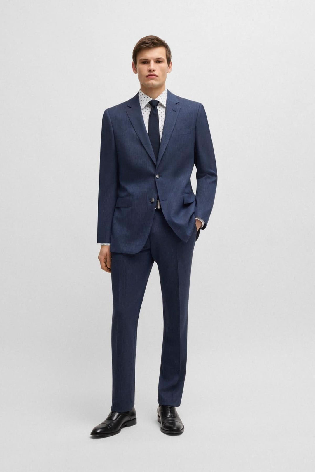 Homme en costume marine avec chemise à motif, look d&