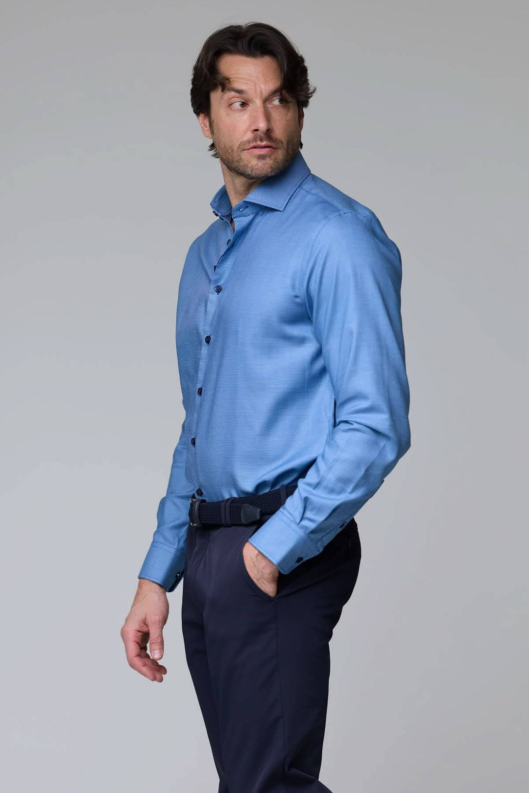 Homme portant une chemise à micro-motif texturé bleu, manches longues, coupe ajustée élégante, idéale pour bureau ou occasion chic.