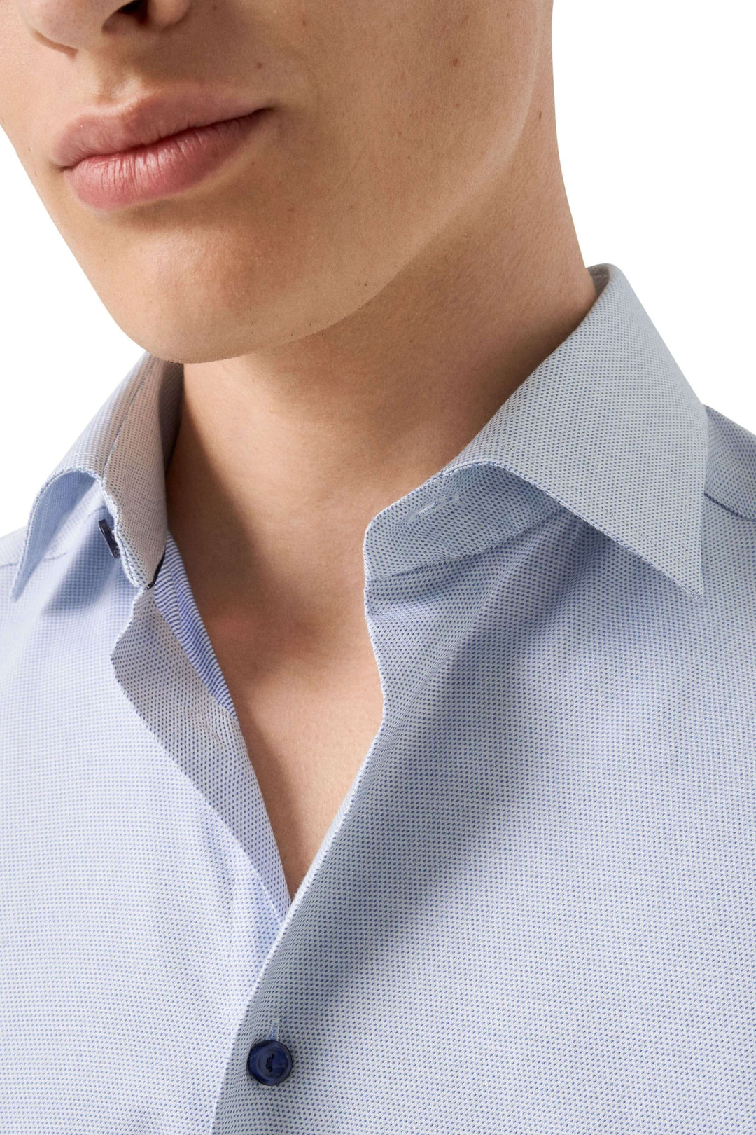 Chemise motif discret avec col ouvert et coupe ajustée pour un look élégant et moderne; idéal pour occasions professionnelles ou spéciales.