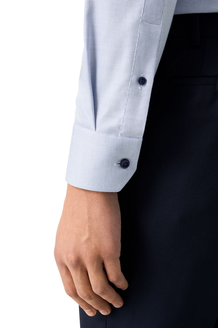 Poignet de chemise motif discret ajustée avec boutons bleus, élégante et moderne, pour un style professionnel.