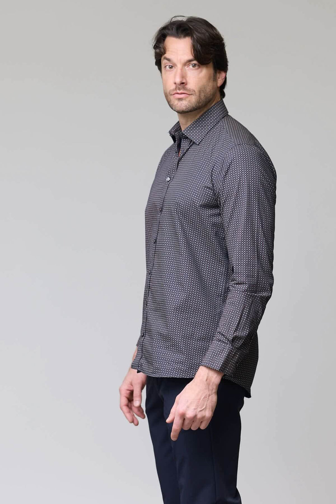 Homme portant une chemise à motif géométrique microfleurs, coupe ajustée et col classique.